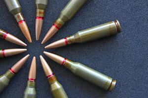 Top view of bullets in the form of aim on clean black fabric. Stock Photo For Military Backgrounds
