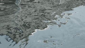 Dark water with ripples on the surface. Defocus blurred transparent white colored clear calm water surface texture with splashes and bubbles. Water waves with shining pattern texture background. video