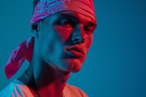 High end Fashion Male Model in Neon pink Bandana Neon Teal Background portrait with Trendsetting Look photo