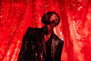 Handsome Male Model in Sequined Black Jacket with Neon Red Trendy portrait with Vibrant Urban Background photo