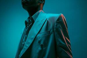 Trendsetting fashion portrait of a male model in a vintage blazer with a neon teal background fusing retro charm with a bold neon twist for a dynamic and stylish look photo