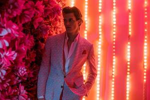 Trendy Model in patterned Suit with Neon Coral Background Modern Look photo