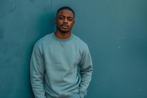 Handsome Fashion Model in Trendy Slate Blue Sweatshirt leaning Against a Wall Lifestyle portrait with Male Fashion Background photo