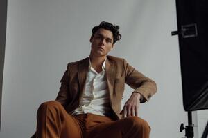 Stylish male model in a crisp white blazer delivering a contemporary high fashion portrait with a sophisticated lifestyle background photo
