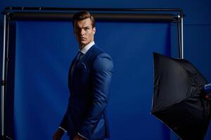 Classic male fashion model in a tailored suit with royal blue background highlighted in an upscale lifestyle portrait with timeless appeal photo
