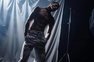 Trendy male model in Couture pants with Black background showcasing a stylish lifestyle portrait of contemporary Males attire photo