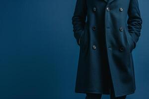 Stylish male model in a slate blue overcoat featuring a coordinating background for a fashion portrait that combines classic style with modern sophistication photo