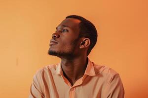 Stylish male model in a long sleeve shirt with a soft peach backdrop featuring a chic portrait that blends modern elegance with a relaxed fashionable touch photo