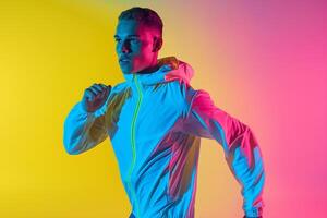 Fashionable male model in perforated gear with a clothing gradient background Highlighting modern athletic style and vibrant design with a chic touch photo