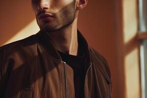 Stylish male model in a zip up jacket with a costume brown background emphasizing a fashionable and lifestyle oriented portrait photo