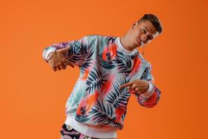 printed Sweatshirt Clad Male with Tangerine Background emphasizing Stylish prints in a Bold Lifestyle portrait photo