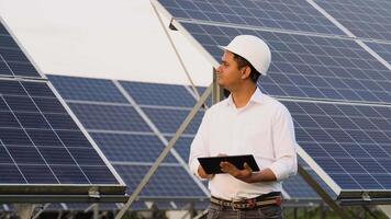 Indian engineer using digital tablet maintaining solar cell panels on station video