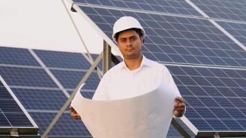 Portrait of Indian engineer with technical documentation at solar power plant video