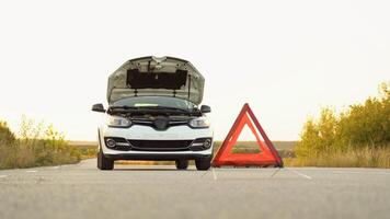 White broken car with problems and a red triangle to warn other road users. Transportation, traveling concept video