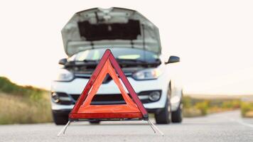 White broken car with problems and a red triangle to warn other road users. Transportation, traveling concept video