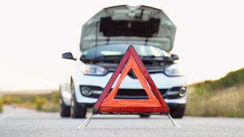 White broken car with problems and a red triangle to warn other road users. Transportation, traveling concept video