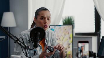 Tech enthusiast reviewing wireless mouse while presenting specifications to public. Attractive social media star doing recommendation for electronic peripheral while sitting at home studio desk. video