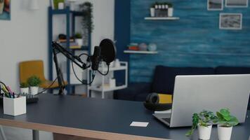 Empty living room studio desk with modern laptop and professional podcast microphone. Social media workstation equipped with digital content creator tools and devices with nobody in it. video