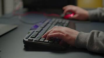 Close-up on hands of pro cyber man playing game using RGB keyboard. Virtual championship in cyberspace, esports player performing on powerful computer during online esports gaming tournament video