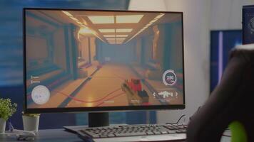 Empty cyberspace with RGB powerful personal computer with first-person shooter game on screen in gaming studio with no people at desk prepared for online esports tournament. Room with no people video