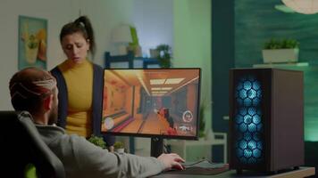 Wife arguing with man gamer during space shooter videogame tournament playing on RGB powerful personal computer. Pro cyber player performing games streaming from home at online championship video