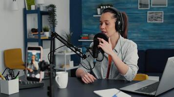 Popular content creator taking a with smartphone while telling a story. Famous vlogger having professional equipment in living room studio talking with audience about last events. video