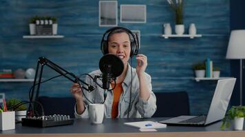 Digital content creator in studio at home recording daily vlog while telling stories. Creative social media influencer presenting to audience world events while sitting in studio living room. video