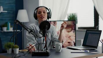 Famous social media influencer tweaking knobs on mixer while recording vlog for sharing platforms. Popular internet star sitting at home studio desk while filming digital content. video