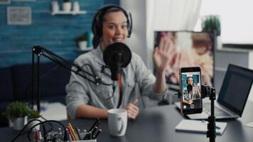 Social media influencer using modern laptop while streaming remote podcast show on smartphone. Creative digital content creator recording daily vlog with modern touchscreen cellphone device. video