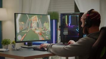 Pro cyber sport gamer playing FPS videogame using RGB keyboard and headset. Virtual shooter game championship in cyberspace, esports player performing on power personal computer in gaming tournament video