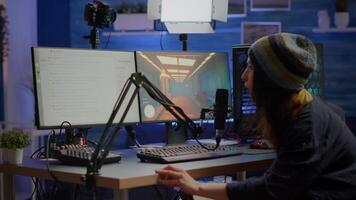 Streamer coming in gaming room playing videogames and talking with team mates on streaming open chat and microphone, checking sound mixer. Cyber performing on powerful computer professional equipment video