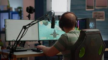Professional streamer winning space shooter videogame at live competition playing from home studio. Online streaming cyber performing during gaming tournament using powerful computer with RGB lights video