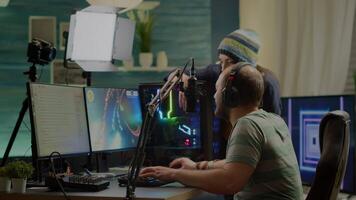 Excited players couple winning online videogames competition using powerful computer celebrating victory. Streamer gamer playing games with RGB keyboard performing at gaming turnament video
