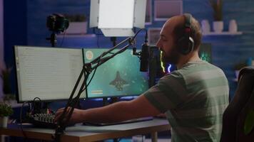 Pro cyber man streaming videogame, reading on stream chat and playing space shooter on RGB powerful computer. Streamer sitting on gaming chair playing game during online esports tournament. video