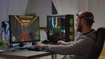 Pro esport man gamer smiling at camera playing first person shooter game gaming on virtual championship event. Online streaming cyber performing on powerful personal computer during tournament video