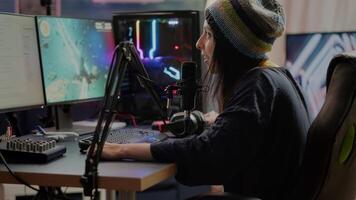 Portrait of woman streamer looking at camera after playing space shooter games using professional RGB keypad on powerful computer. Pro player streaming online videogames in gaming home studio video