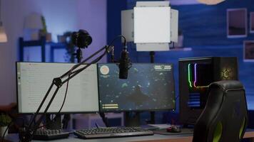 Empty gaming studio with RGB led lights powerful personal computer for streaming online competition. Display with stream chat prepared for virtual tournament, living room with nobody in video