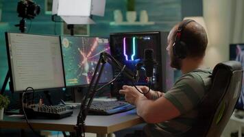 Pro cyber streamer losing videogame tournament while wearing professional headset holding wireless controller. Defeated gamer using joystick for online competition late at night in gaming room video