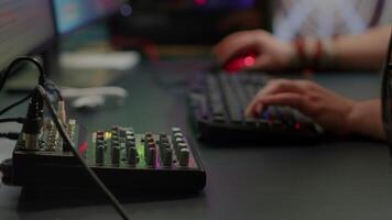 Close up of professional keyboard with RGB lighting streaming at chat. Player using powerful gaming computer in home studio of esport game typing at keypad playing space shooter videogame. video