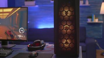 Close-up of RGB system desktop, pro gamer playing first person shooter game during online competition. Streaming studio is equipped with professional setup with powerful pc ready for online game video
