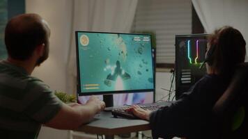 Gaming over for nervous pro couple gamers, playing space shooter during virtual competition tournament using professional headset. Sad online streaming cybers performing using RGB powerful computer. video