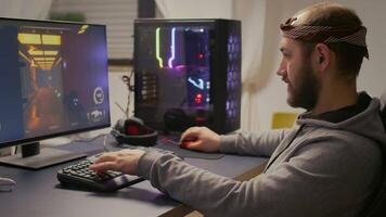 Cyber gamer playing esport shooter game for virtual tournament on powerful computer using RGB keyboard and professional mouse. Player streaming online games in gaming home studio. video
