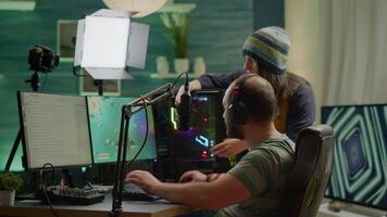 Nervous players couple losing online videogames competition using powerful computer screaming at each other. Streamer gamer playing games with RGB keyboard performing at gaming turnament video