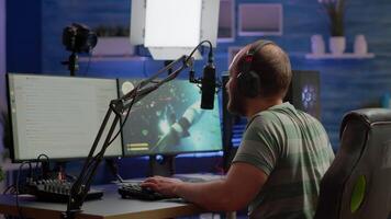 Man streamer playing space shooter videogame using headset, talking on stream chat and microphone. Online streaming cyber performing on RGB powerful professional computer during gaming tournament video