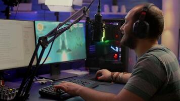 Streamer man wearing headset start to play online space shooter games. Pro e-sport player playing gaming tournament on RGB computer, using modern streaming technology video