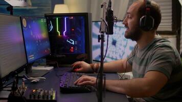 Pro gamer move the buttons on professional mixer late at night in streaming home studio. Streamer playing space shooter games tournament using RGB keyboard in room with neon lights. video