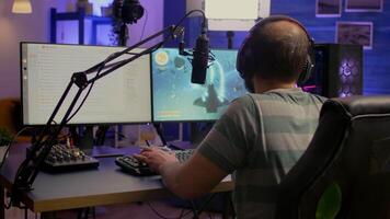 Pro esport streamer using headphones and talking with team on streaming services during space shooter competition. Virtual game in cyberspace, esports player performing on powerful computer video