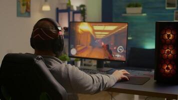 Videogamer playing graphics cyber space sitting on gaming chair using technology network wireless. Man streaming games online for fun using RGB equipment for online championship video