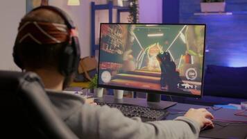 Professional player with headphones performing first person shooter game with modern graphics at virtual championship. Online streaming cyber using technology network wireless video
