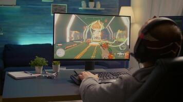Over shoulder shot of man after losing at games on computer using professional RGB equipment. Defeted player playing first person shooter games using modern technology network wireless video